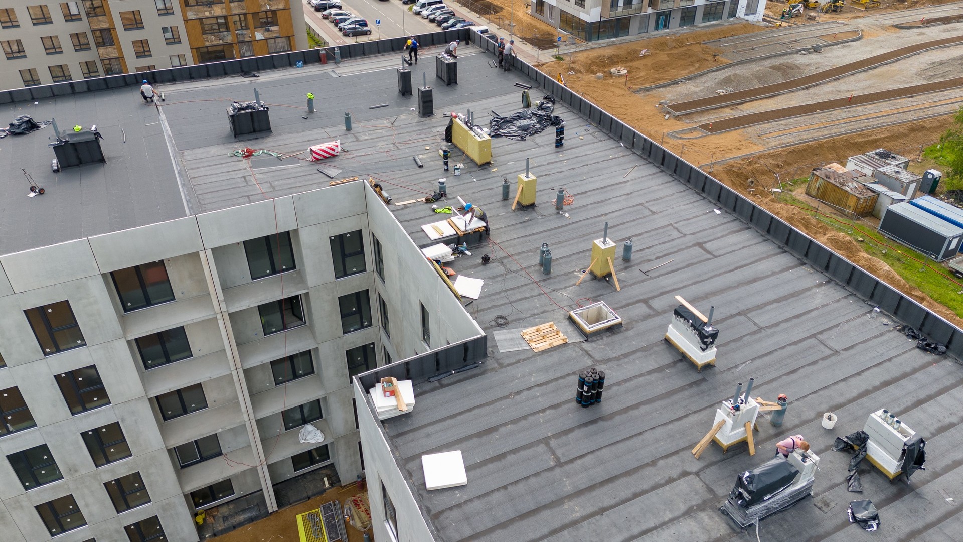 Aerial View of Construction Workers on Flat Roof
